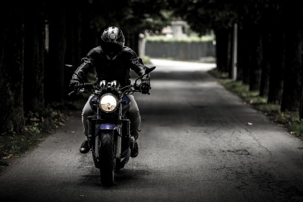Un homme conduit une moto sur une route de campagne